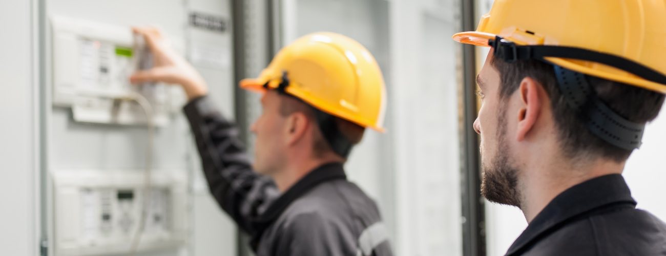 Engineer in a hard hat working on an electrical distribution panel